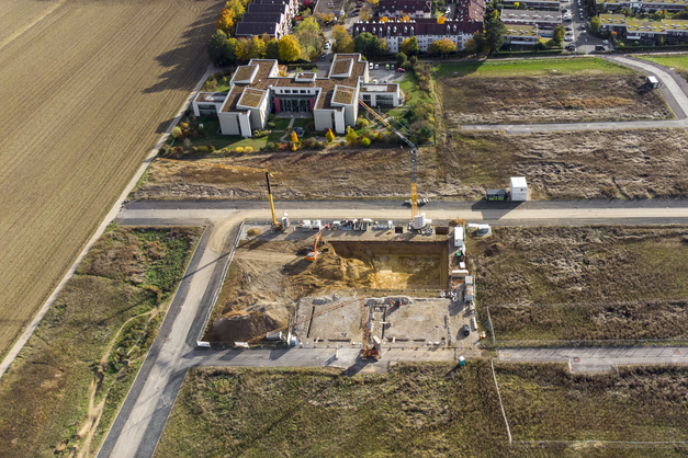 Aerial view of a residential subdivision in early site development, with graded lots and new roads
