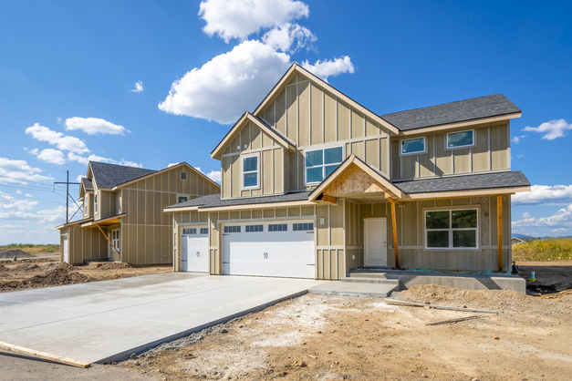 A newly built single-family home nearing completion on a cleared lot