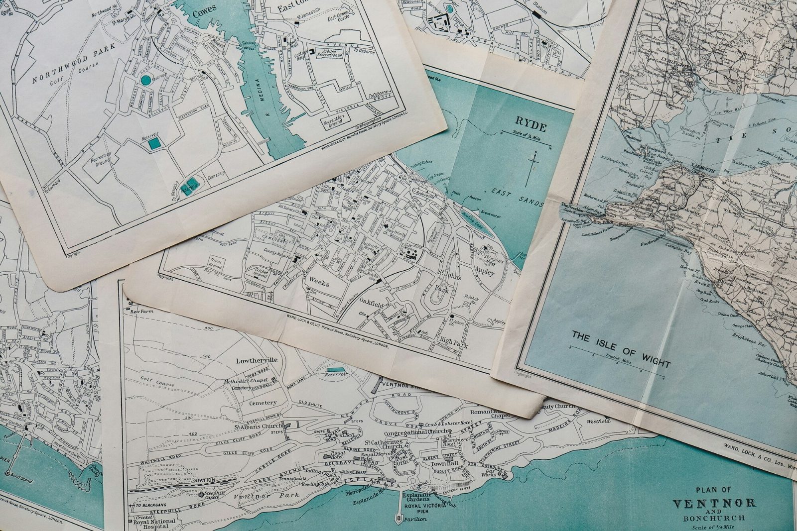 Overlapping historical zoning and parcel maps spread across a table